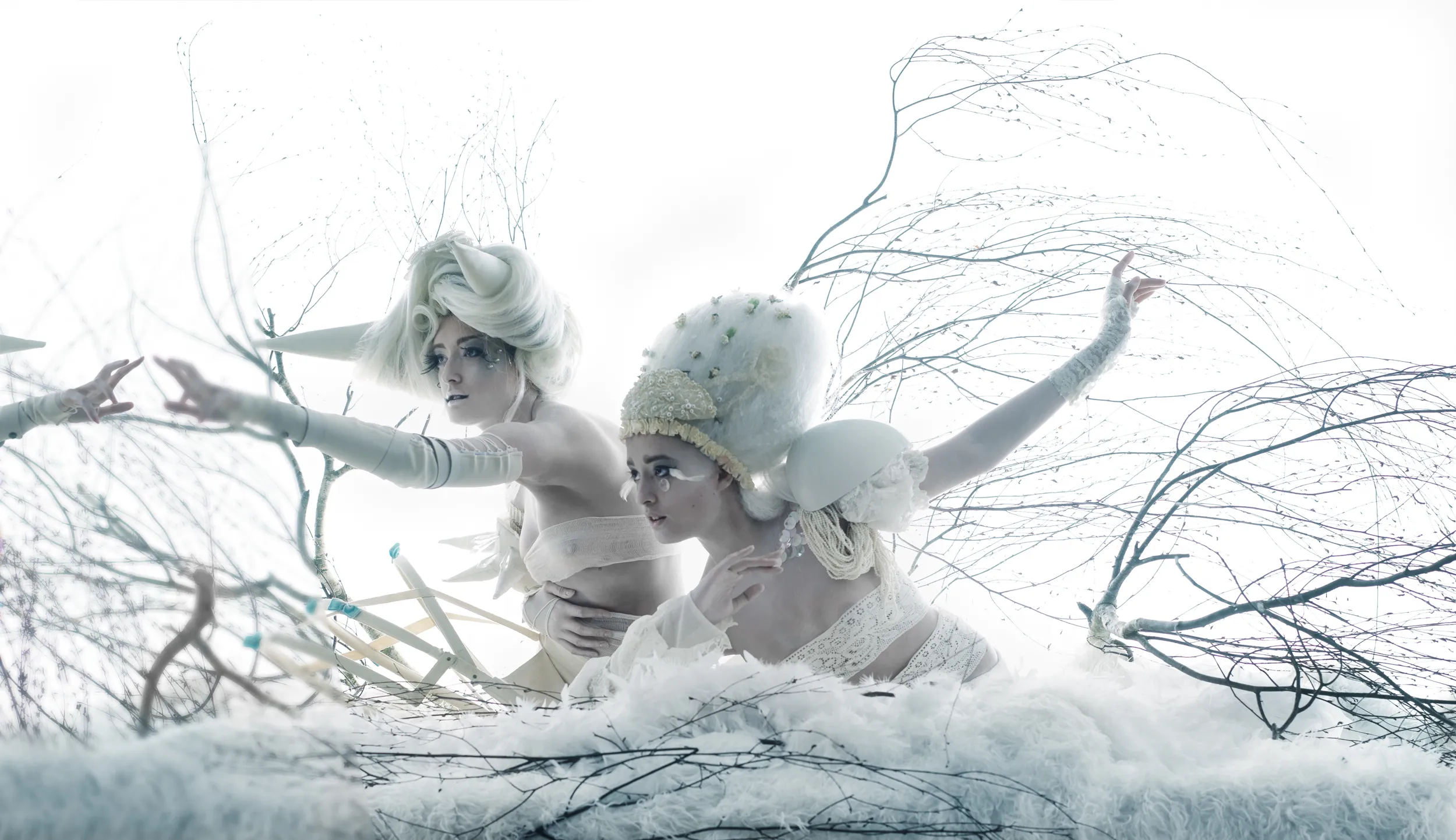 Scena onirica e fiabesca: due figure eteree in bianco, allegorie del bene e del male, interagiscono tra rami intrecciati e nubi. Fotografia concettuale di Gildardo Gallo, serie Pneuma.